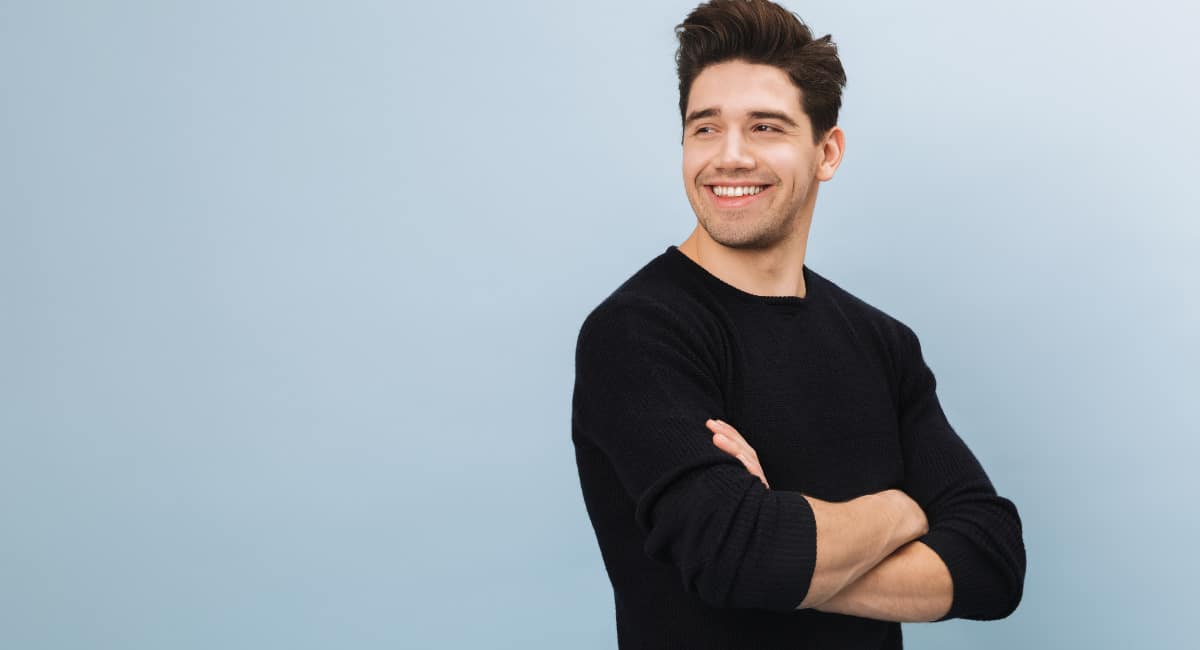 Portrait of a cheerful handsome young man standing isolated over blue background