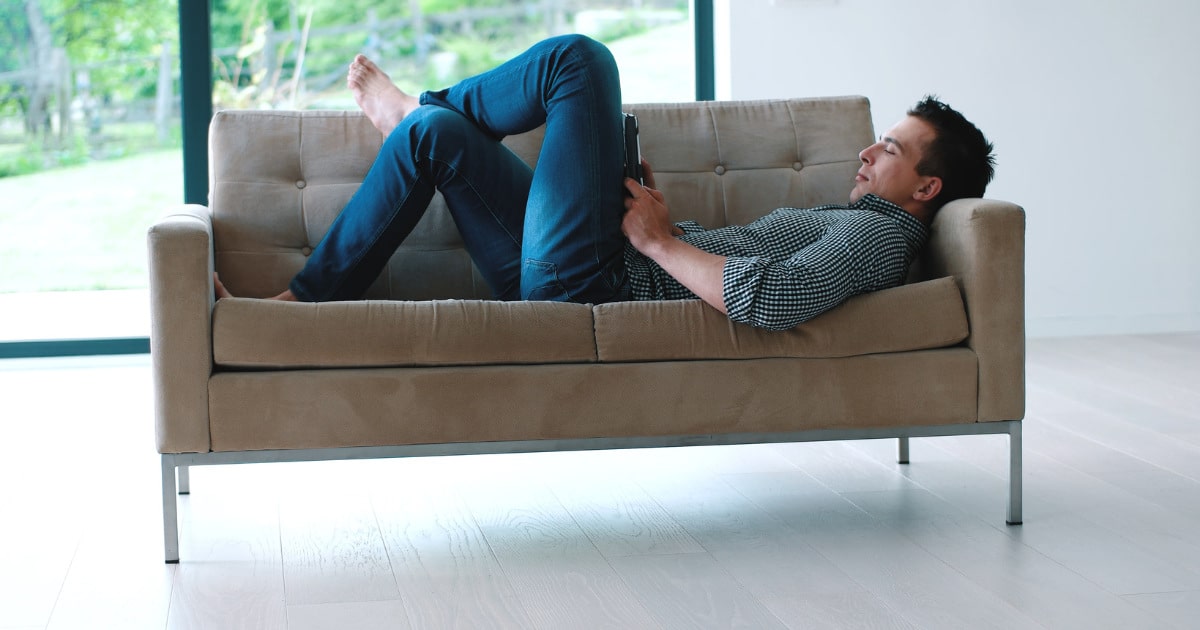 a man laying on couch resting